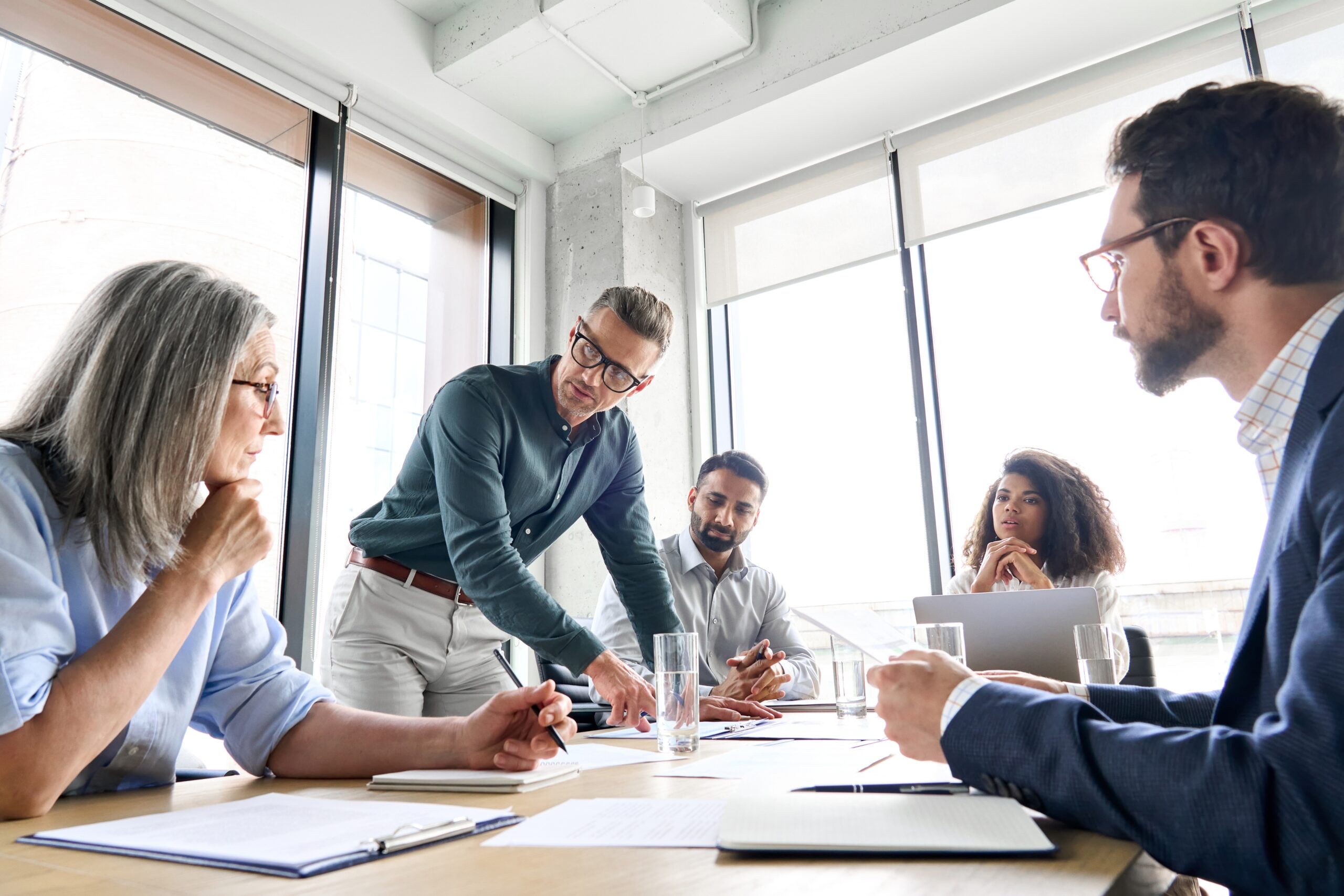 People in a bright office gathered round a desk discussing